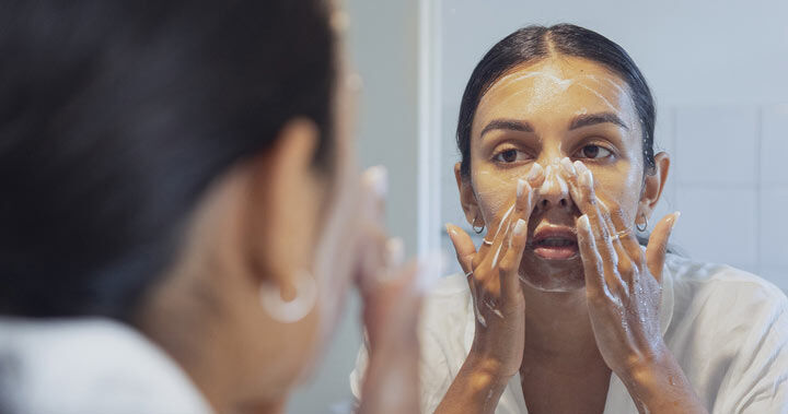 Kvinne rengjør ansiktet sitt
